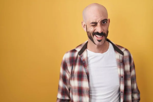 有胡子的西班牙男人站在黄色的背景上眨着眼睛 带着性感的表情 笑容满面地看着摄像机 — 图库照片