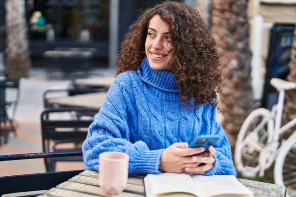 Young Hispanic Woman Using Smartphone Reading Book Coffee Shop Terrace — ストック写真