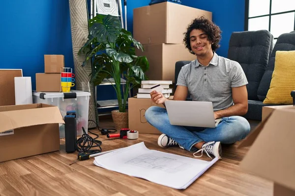 Jonge Spaanse Man Met Laptop Creditcard Vloer Een Nieuw Huis — Stockfoto