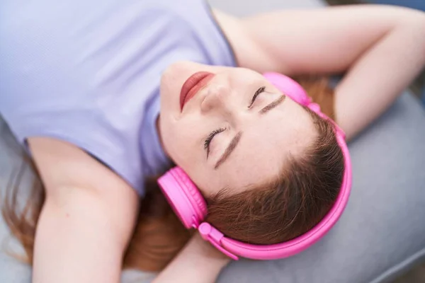 Jonge Roodharige Vrouw Luisteren Naar Muziek Liggend Bank Thuis — Stockfoto