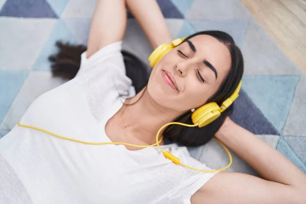 Young Hispanic Woman Listening Music Lying Floor Home — ストック写真