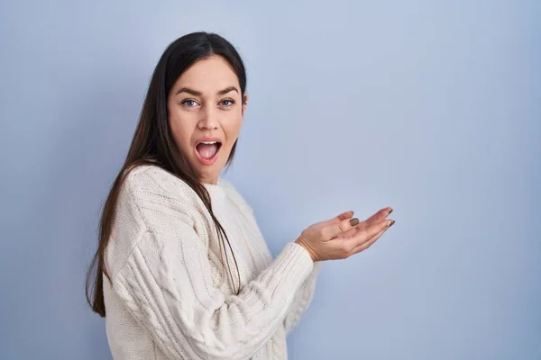 Young Brunette Woman Standing Blue Background Pointing Aside Hands Open — Stockfoto