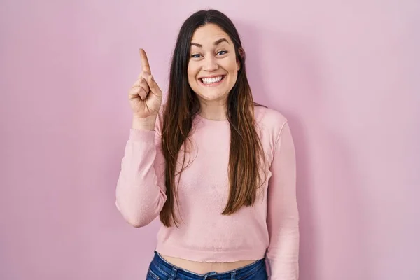 Young Brunette Woman Standing Pink Background Pointing Finger Successful Idea — Zdjęcie stockowe