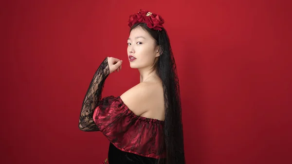 stock image Young chinese woman wearing katrina costume with relaxed expression over isolated red background