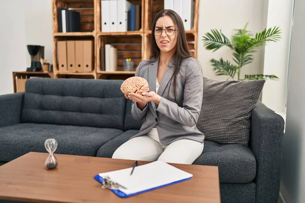 Hispanic Woman Working Therapy Office Holding Brain Clueless Confused Expression — Stock Photo, Image