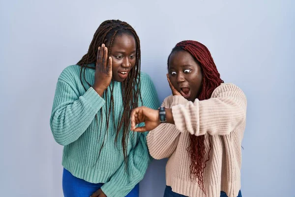 Дві Африканські Жінки Стоять Над Синім Тлом Дивлячись Час Спостереження — стокове фото