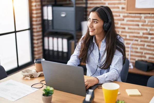 stock image Young hispanic girl business worker using laptop and headphones working at office