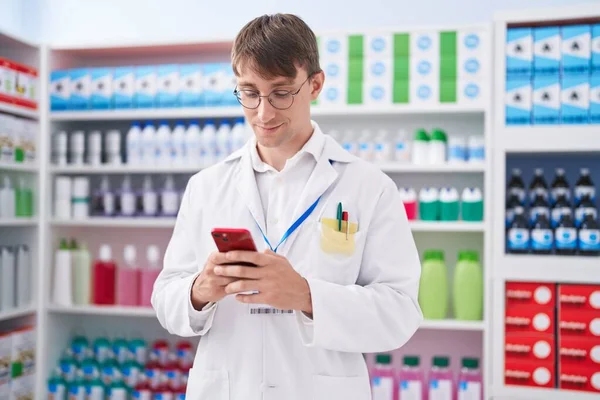 Молодой Кавказский Фармацевт Использует Смартфон Работающий Аптеке — стоковое фото