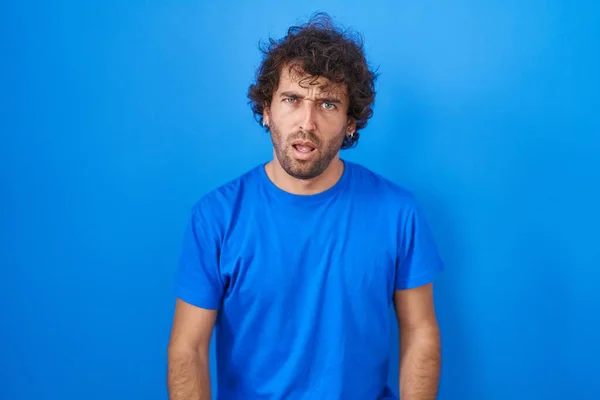 Hispánský Mladý Muž Stojící Nad Modrým Pozadím Šokovaném Obličeji Skeptický — Stock fotografie