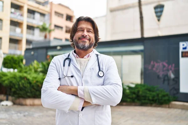 Médico Hombre Mediana Edad Sonriendo Confiado Pie Con Los Brazos —  Fotos de Stock