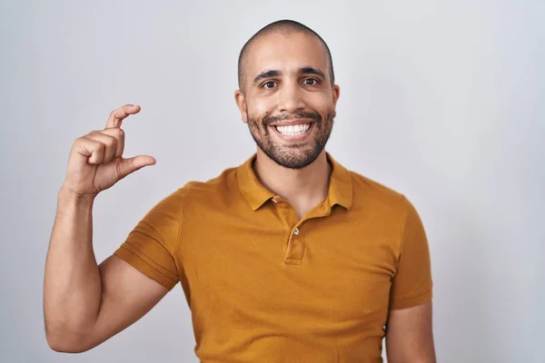 有胡子的西班牙男人站在白色的背景上 微笑着 自信地做手势 手拿着小尺寸的标志 手拿着手指 手拿着相机 计量概念 — 图库照片
