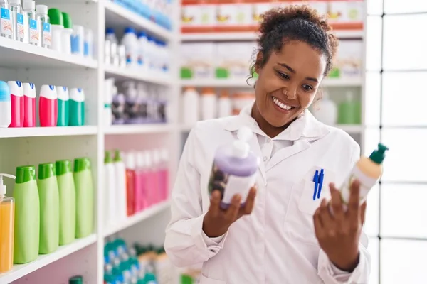 African American Woman Pharmacist Smiling Confident Holding Gel Bottles Pharmacy — Stockfoto