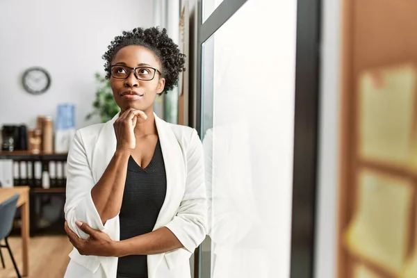 アフリカ系アメリカ人の女性ビジネスワーカーがオフィスで疑いの表情で立っている — ストック写真