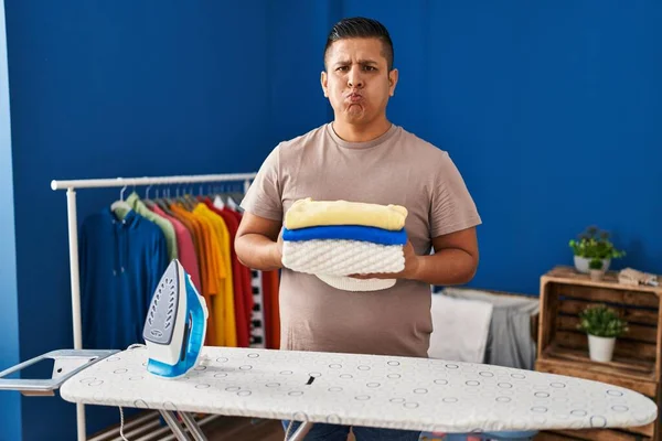 Şişmiş Yanakları Komik Bir Suratla Ütüledikten Sonra Çamaşırları Katlayan Spanyol — Stok fotoğraf