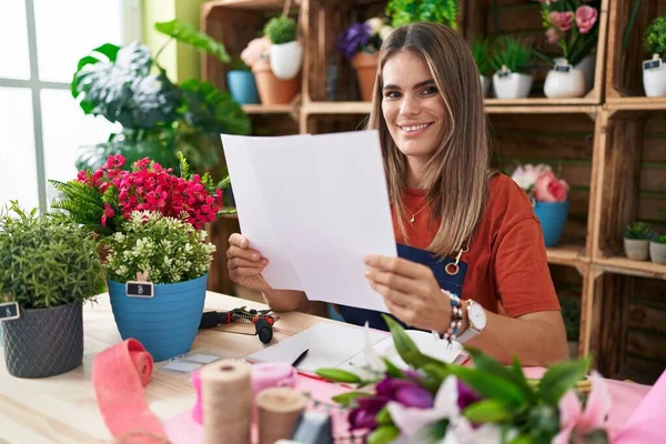 Young Beautiful Hispanic Woman Florist Reading Document Sitting Table Flower — Fotografia de Stock