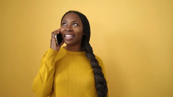Африканская Женщина Улыбается Разговаривая Телефону Изолированном Желтом Фоне — стоковое фото