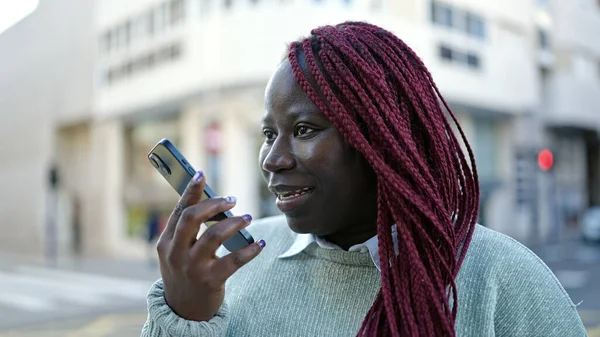 編組髪を持つアフリカの女性は通りでスマートフォンで音声メッセージを送信 — ストック写真
