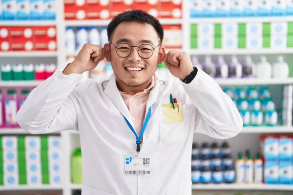 Китайський Молодий Чоловік Який Працює Аптеці Посміхається Тягнучи Вуха Пальцями — стокове фото