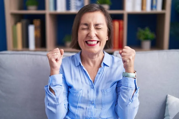 Middelbare Leeftijd Spaanse Vrouw Zit Bank Thuis Enthousiast Voor Succes — Stockfoto