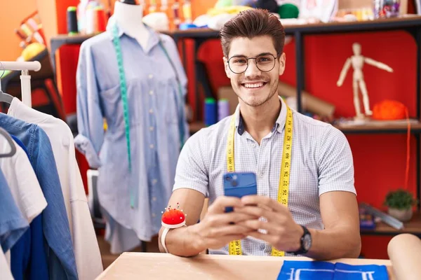 Jovem Hispânico Homem Alfaiate Sorrindo Confiante Usando Smartphone Atelier — Fotografia de Stock