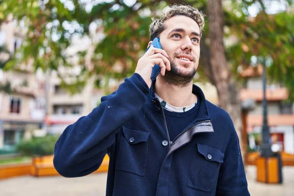 Mladý Muž Usmívá Sebevědomě Mluvit Smartphone Parku — Stock fotografie
