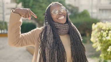 Afrikalı kadın kendini parka göstererek gülümsüyor.