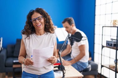 Orta yaşlı İspanyol kadın müzik stüdyosunda şarkı söylüyor kameraya seksi bir ifadeyle bakıyor, neşeli ve mutlu bir yüzle.. 