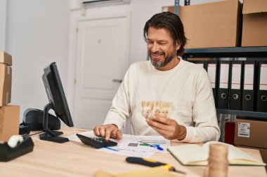 Middle age man ecommerce business worker counting denmark kroner banknotes at office