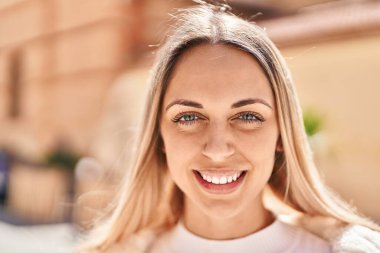 Sokakta kendinden emin gülümseyen genç bir kadın