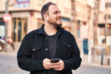 Sokakta akıllı telefon kullanan, kendine güvenen genç bir İspanyol.