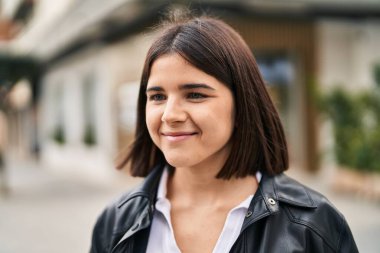 Young beautiful hispanic woman smiling confident looking to the side at street