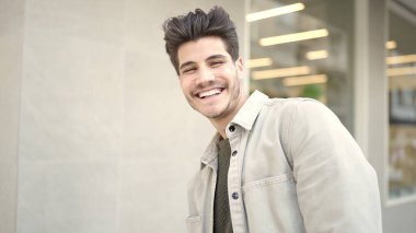 Sokakta kendinden emin gülümseyen İspanyol genç adam.