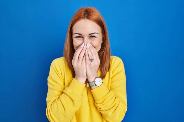 Young Woman Standing Blue Background Laughing Embarrassed Giggle Covering Mouth — Stockfoto