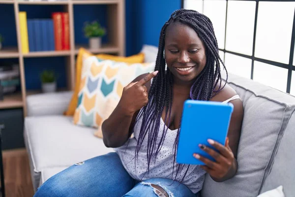 Νεαρή Αφρικανή Γυναίκα Που Χρησιμοποιεί Touchpad Κάθεται Στον Καναπέ Χαμογελώντας — Φωτογραφία Αρχείου