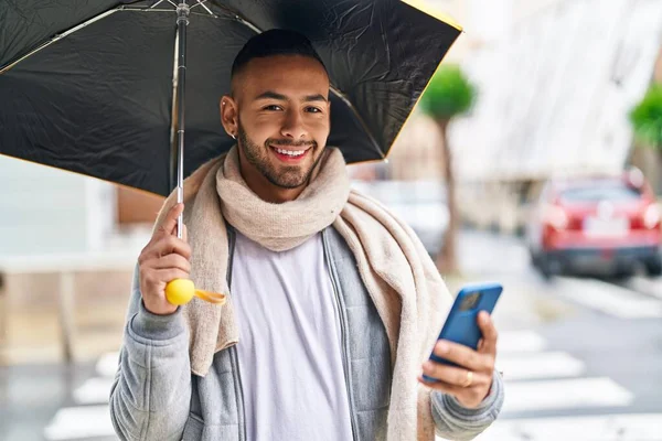 Uomo Afroamericano Utilizzando Smartphone Che Tiene Ombrello Strada — Foto Stock
