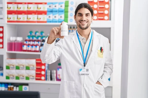 Young Hispanic Man Pharmacist Smiling Confident Holding Pills Bottle Pharmacy — Stock Photo, Image