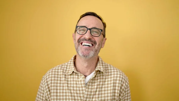 Hombre Mediana Edad Sonriendo Confiado Usando Gafas Sobre Fondo Amarillo — Foto de Stock