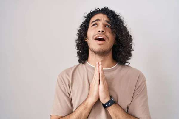 Hispánec Kudrnatými Vlasy Stojící Nad Bílým Pozadím Prosící Modlící Rukama — Stock fotografie