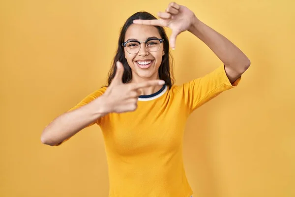 Jovem Brasileira Vestindo Óculos Sobre Fundo Amarelo Sorrindo Fazendo Moldura — Fotografia de Stock