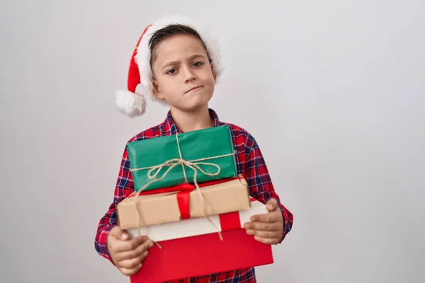 他那头戴圣诞礼帽的惊慌失措的小男孩带着怀疑和紧张的心情 因为问题皱着眉头 消极的人 — 图库照片