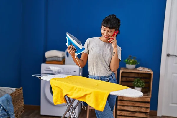 Νεαρή Γυναίκα Μιλάει Στο Smartphone Σιδερώνοντας Ρούχα Στο Πλυσταριό — Φωτογραφία Αρχείου