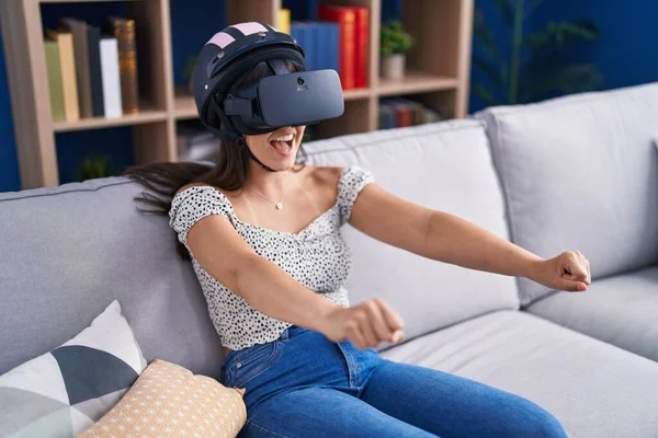 年轻美丽的惊慌失措的女人在家里用虚拟现实眼镜玩电子游戏 — 图库照片