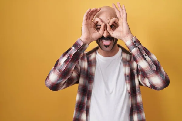 Hispanic Man Beard Standing Yellow Background Doing Gesture Binoculars Sticking — 스톡 사진