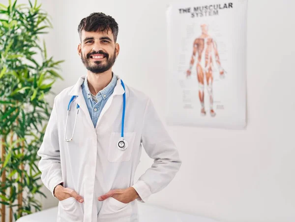 Mladý Hispánec Nosí Lékařskou Uniformu Usmívá Klinice — Stock fotografie