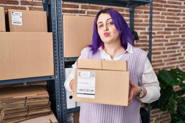另外一个身材魁梧的女人在小企业工作着紫色的头发 手里拿着盒子看着摄像机吹着一个吻是可爱又性感的 爱的表达 — 图库照片
