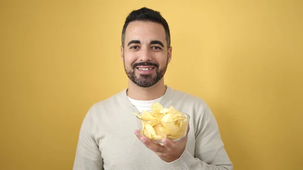 Mladý Hispánec Muž Usmívá Sebevědomě Drží Brambory Přes Izolované Žluté — Stock fotografie