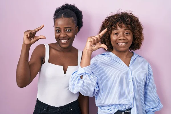 Dos Mujeres Africanas Pie Sobre Fondo Rosa Sonrientes Confiadas Haciendo —  Fotos de Stock