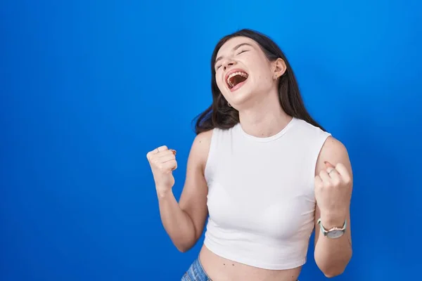 Mladá Běloška Stojící Nad Modrým Pozadím Velmi Šťastná Nadšená Dělá — Stock fotografie