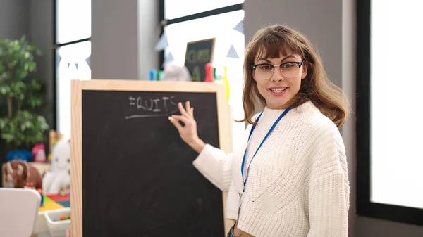 幼稚園で黒板に単語を教える若い白人女性 — ストック写真