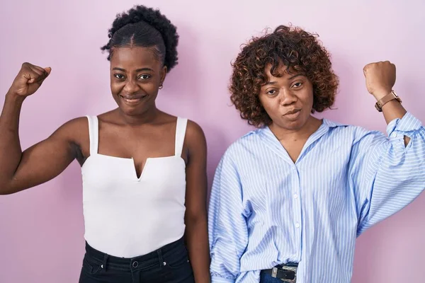 Duas Mulheres Africanas Sobre Fundo Rosa Pessoa Forte Mostrando Músculo — Fotografia de Stock